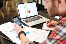 Man Holding Cell Phone While Doing Business Work