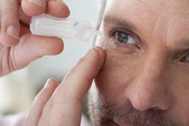 Man Putting Eyedrops Into His Eye