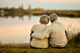 Older Couple Embracing in Front of Lake