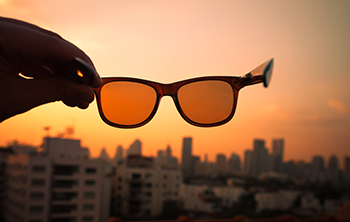 Person Holding Sunglasses to the Sky