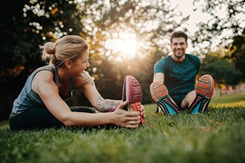 Woman and Man Stretching on Grass