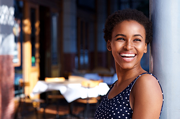 Woman Smiling While Leaning Against a Wall