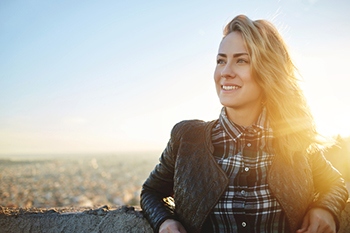 Woman With Sun Behind Her Smiling